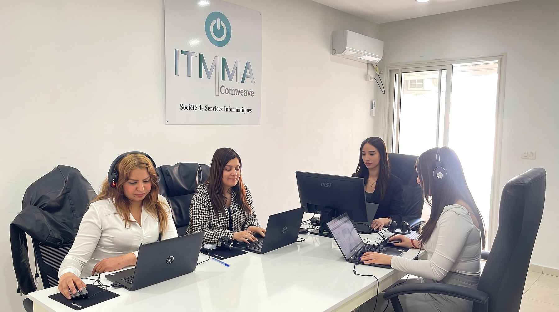 Équipe IT-MMA en salle projet à Bizerte — réunion technique avec le logo de la société